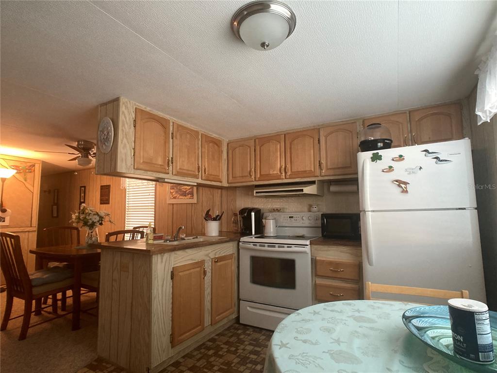 1710 7th Street Southwest, Unit 27 Ruskin, FL 33570 - Photo 9 of 26 a kitchen with a sink a stove and refrigerator