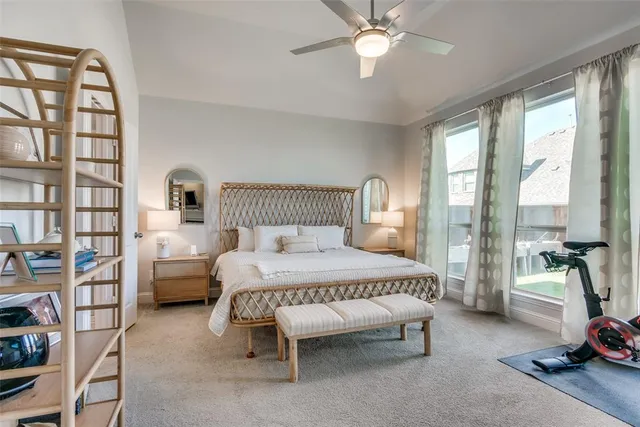 a bedroom with a bed and a flat tv screen on dresser