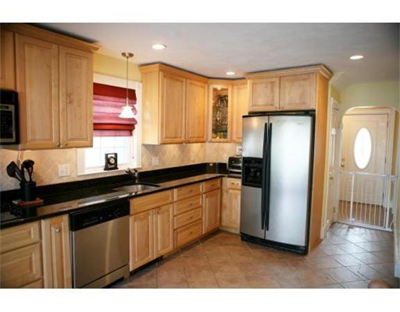 25 Barnes Street Waltham, MA 02453 - Photo 6 of 12 a kitchen with a refrigerator a sink and cabinets