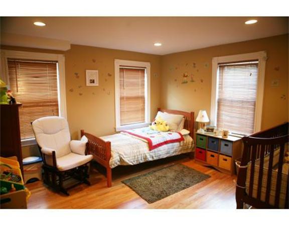 25 Barnes Street Waltham, MA 02453 - Photo 9 of 12 a bedroom with a bed and wooden floor