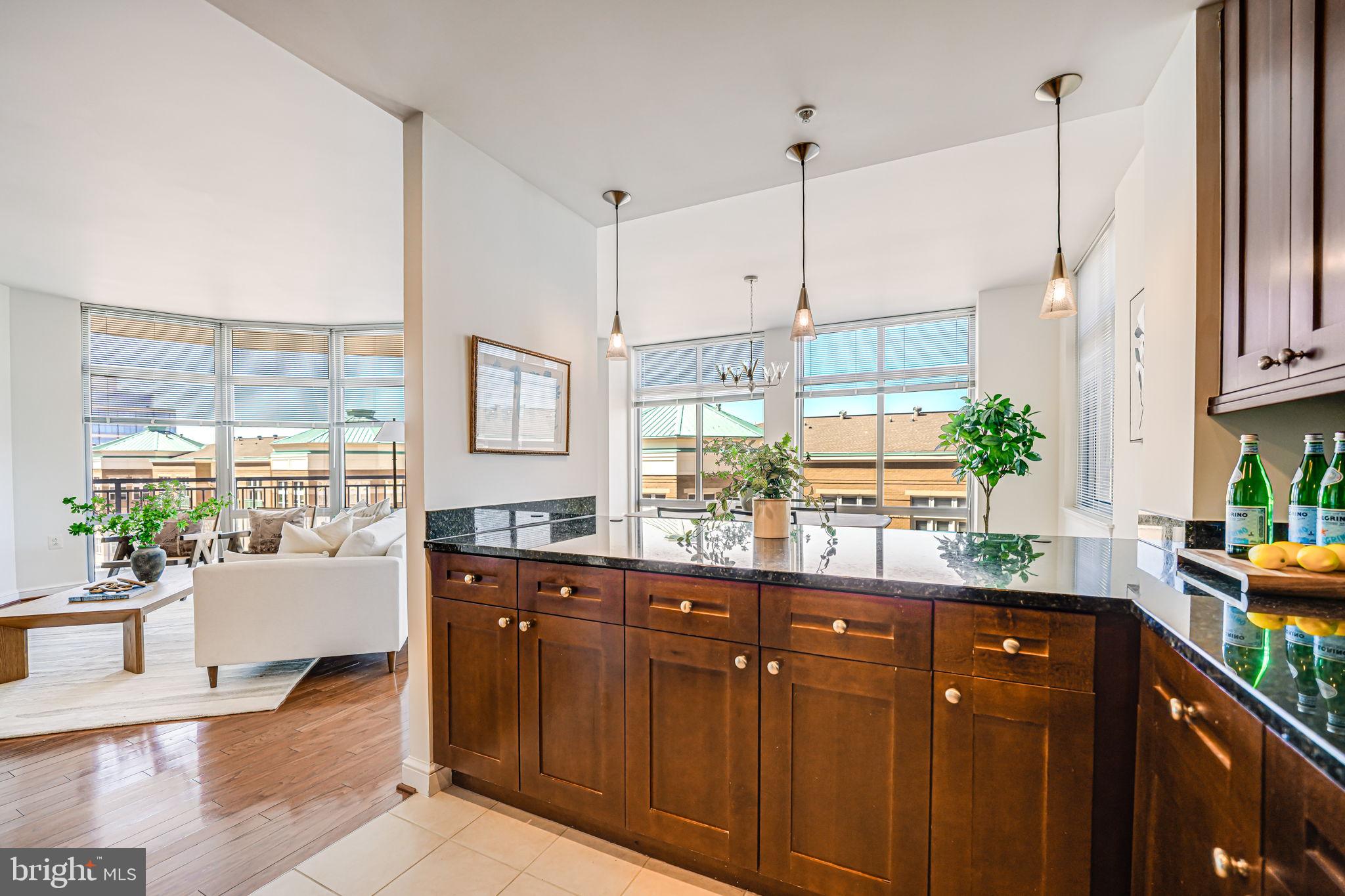 11990 Market Street, Unit 413 Reston, VA 20190 - Photo 11 of 82 a kitchen with stainless steel appliances granite countertop a sink a stove and a wooden floors