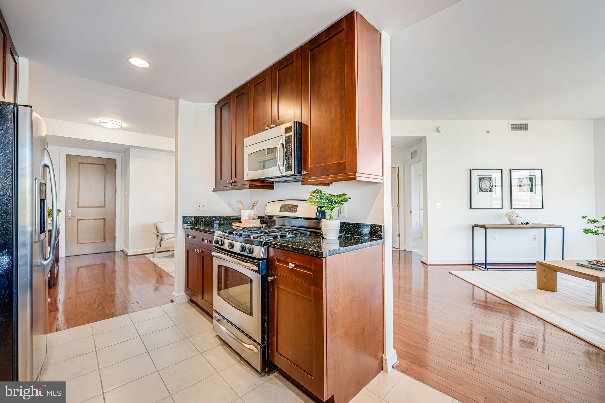 11990 Market Street, Unit 413 Reston, VA 20190 - Photo 12 of 82 a kitchen with stainless steel appliances granite countertop a stove a sink and a refrigerator