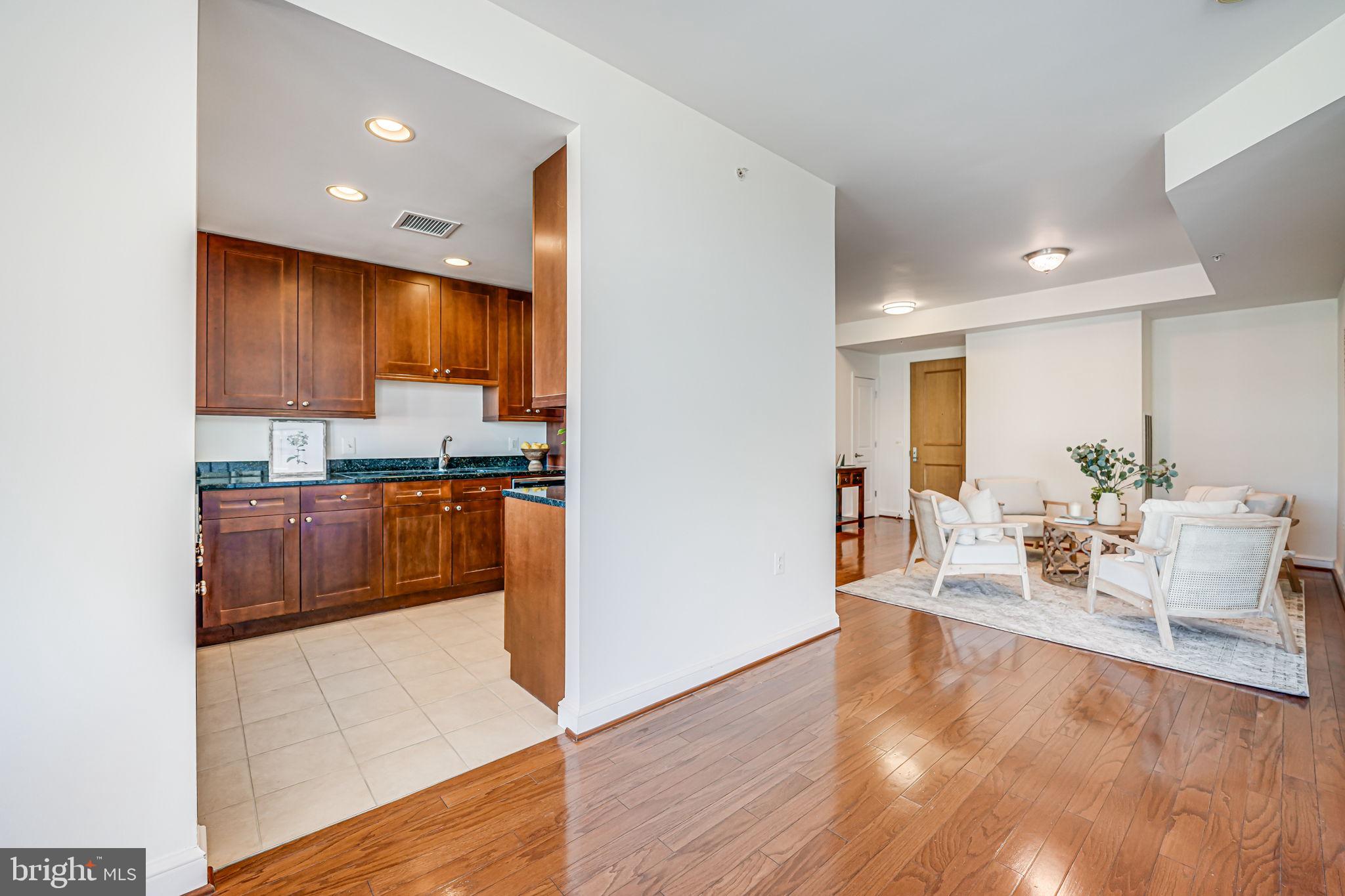 11990 Market Street, Unit 413 Reston, VA 20190 - Photo 14 of 82 a kitchen with stainless steel appliances a refrigerator a sink dishwasher and a stove with wooden floor