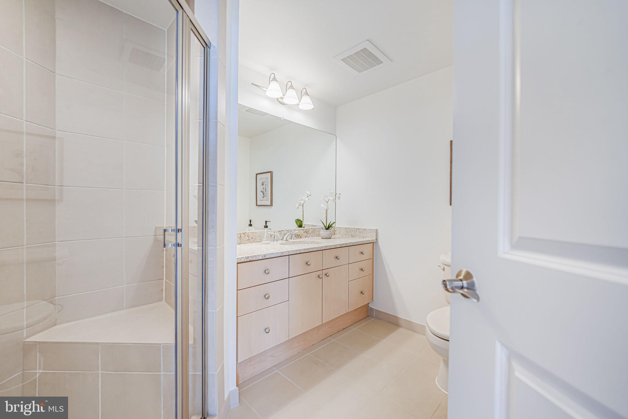 11990 Market Street, Unit 413 Reston, VA 20190 - Photo 29 of 82 a bathroom with a double vanity sink a mirror and a bathtub