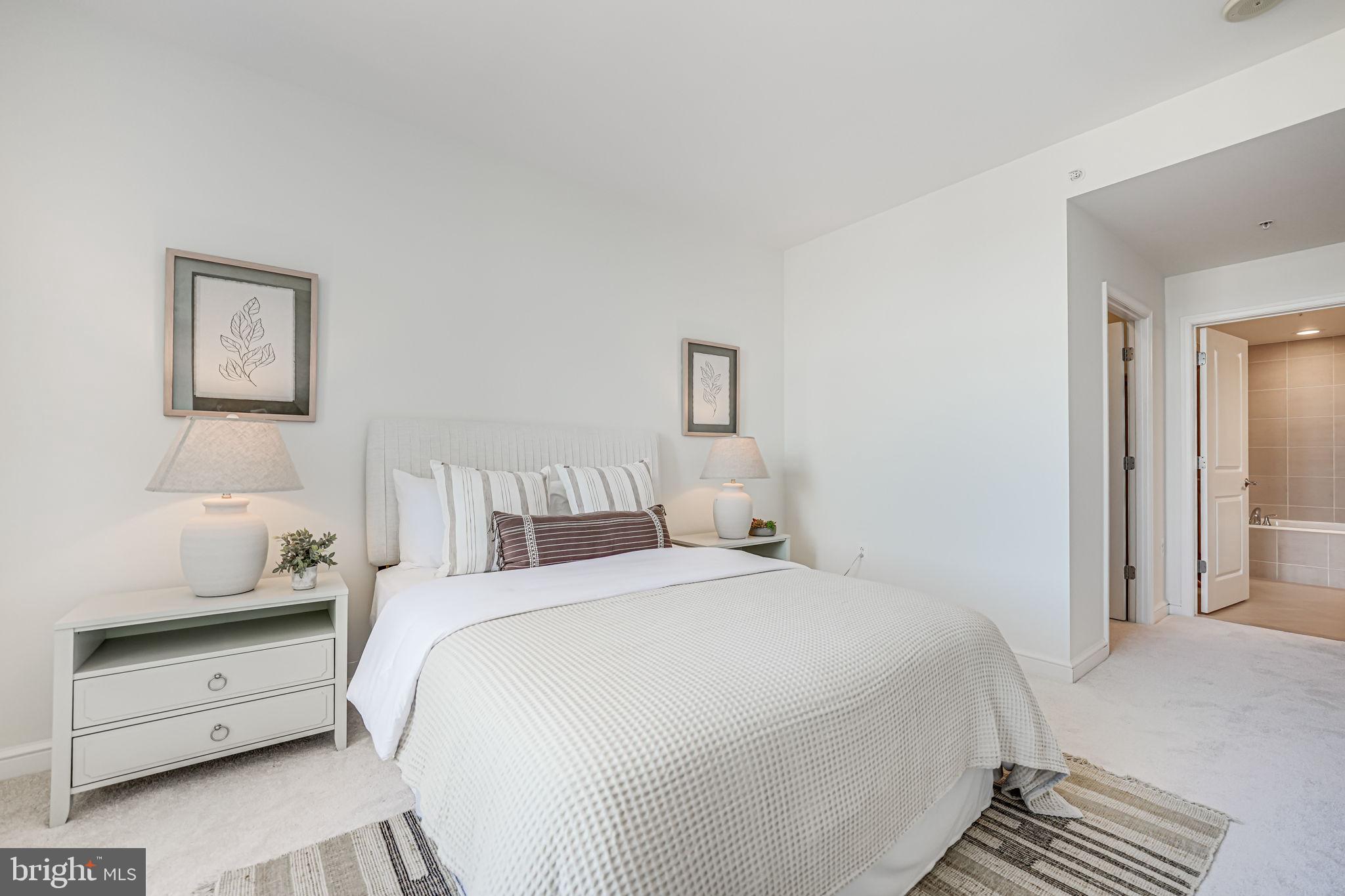 11990 Market Street, Unit 413 Reston, VA 20190 - Photo 32 of 82 a bedroom with a bed and a night stand