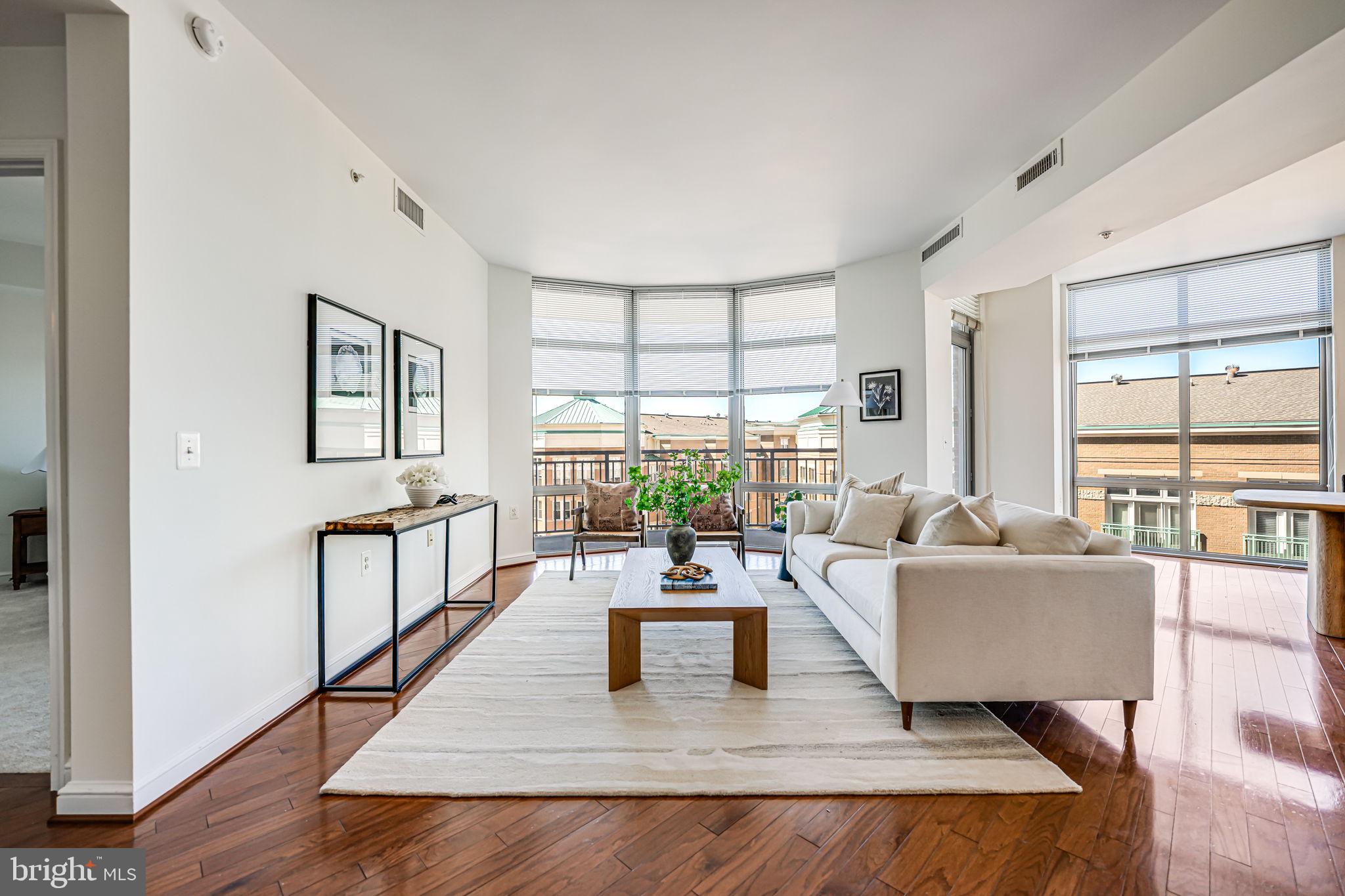 11990 Market Street, Unit 413 Reston, VA 20190 - Photo 5 of 82 a living room with furniture large window and wooden floor