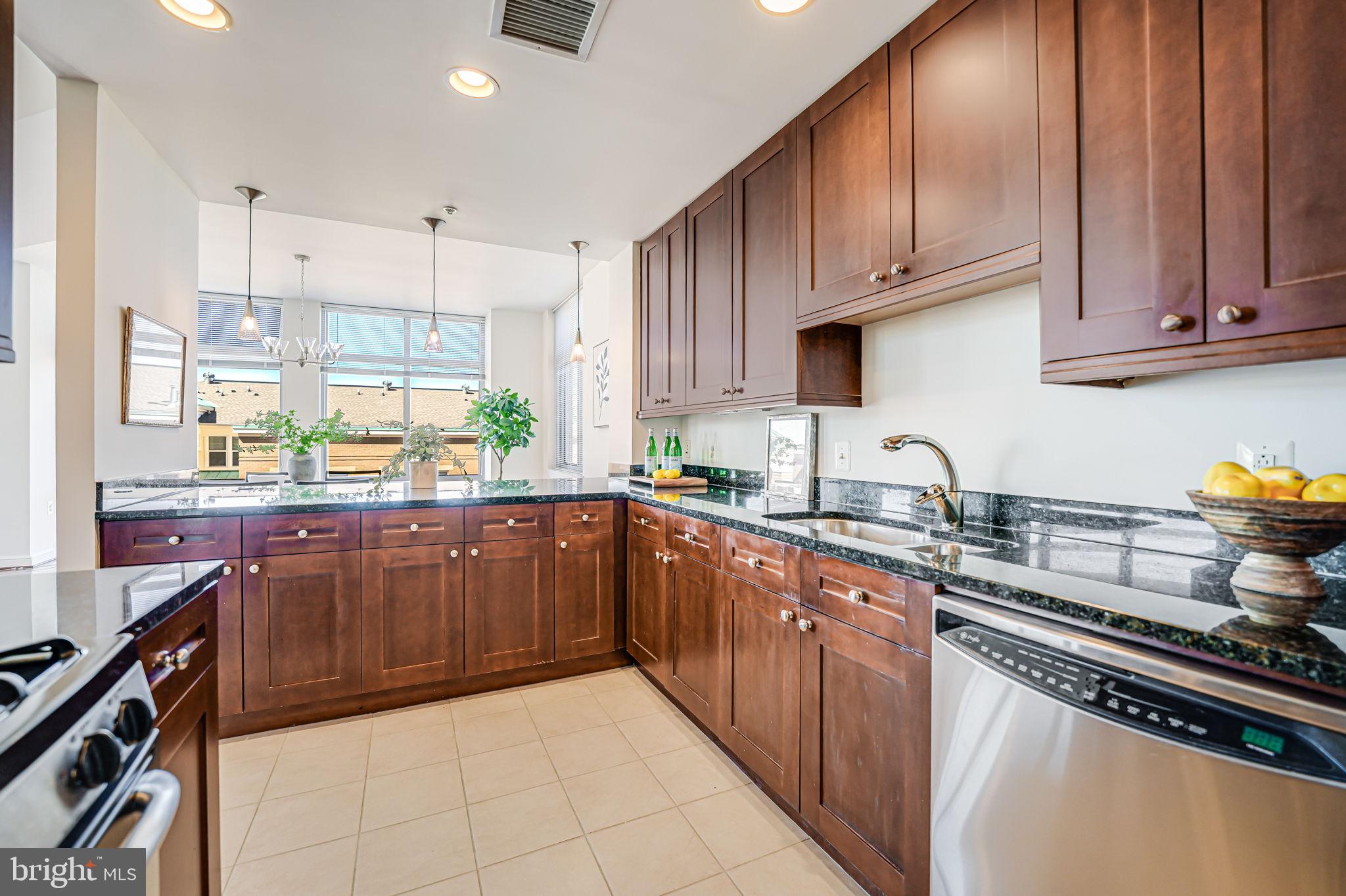 11990 Market Street, Unit 413 Reston, VA 20190 - Photo 10 of 82 a kitchen with stainless steel appliances granite countertop a stove a sink dishwasher and a refrigerator