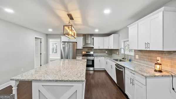 a view of kitchen and center island in wooden floor
