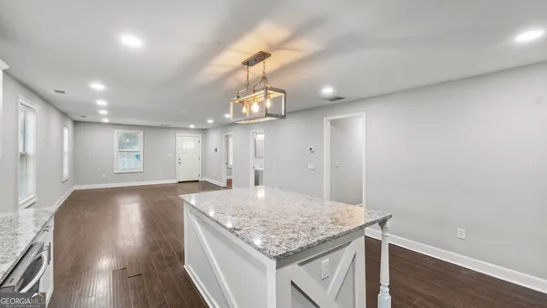 a view of a big room with wooden floor and windows