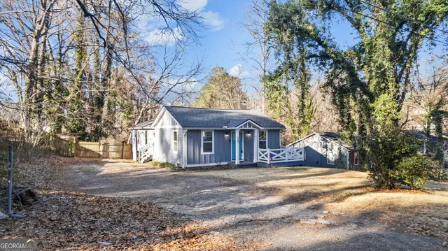 a view of a house with a large tree in front of it
