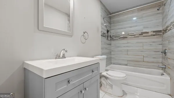 a bathroom with a toilet sink vanity and mirror