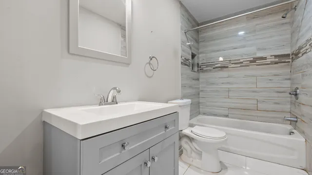a bathroom with a toilet sink vanity and mirror