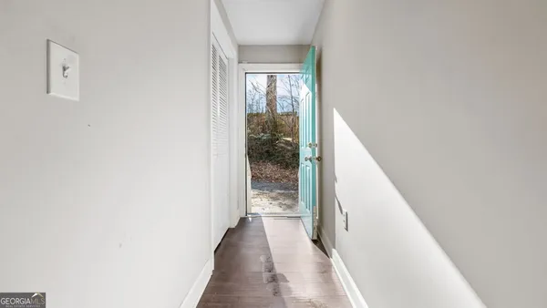 a view of an empty room with a window and wooden floor