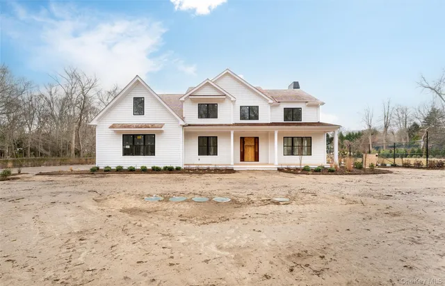 a view of a white house with a yard covered in snow