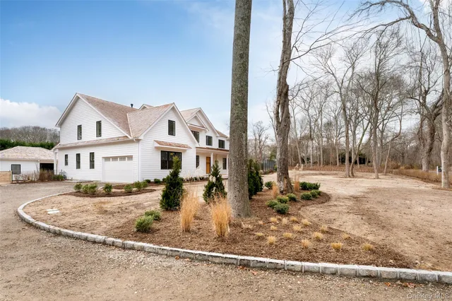 a view of a house with a big yard and large trees