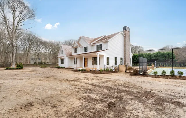 a view of a large white house with a yard covered in snow
