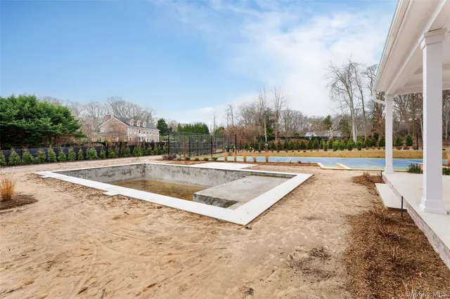 a front view of a house with garden and trees