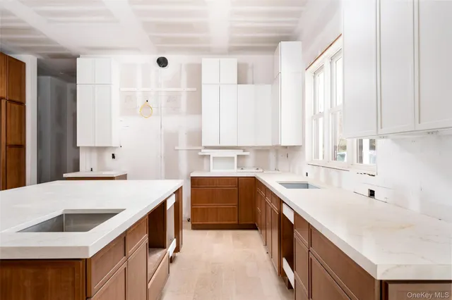 a kitchen with a sink a stove and white cabinets