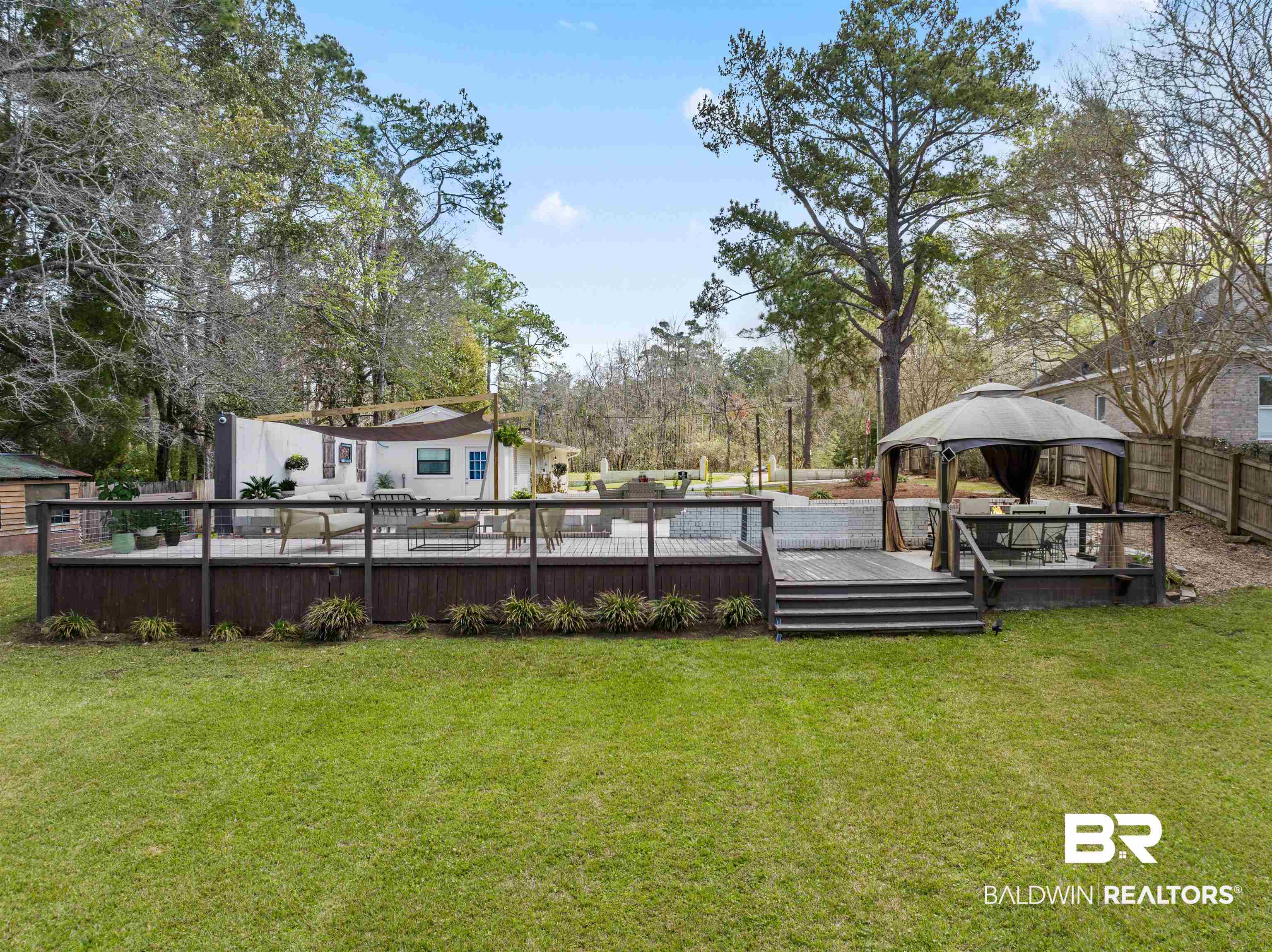 17595 River Road Summerdale, AL 36580 - Photo 24 of 29 Fenced yard featuring a gazebo, a deck, and view of scattered trees