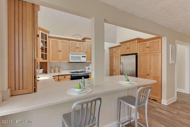 39 Solana Road Ponte Vedra Beach, FL 32082 - Photo 12 of 32 a kitchen with a table chairs and white cabinets