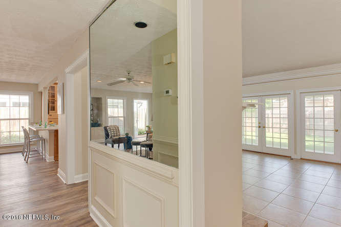 39 Solana Road Ponte Vedra Beach, FL 32082 - Photo 15 of 32 a hallway with a dining table chairs and couches with wooden floor