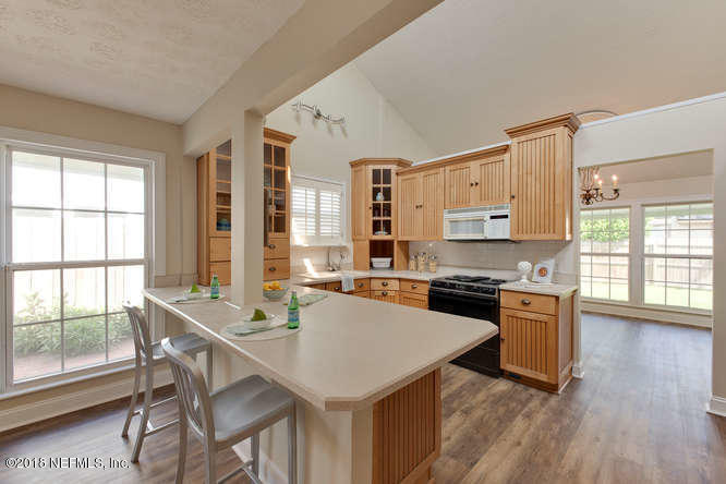 39 Solana Road Ponte Vedra Beach, FL 32082 - Photo 10 of 32 a kitchen with stainless steel appliances granite countertop a stove a sink a microwave and wooden floor