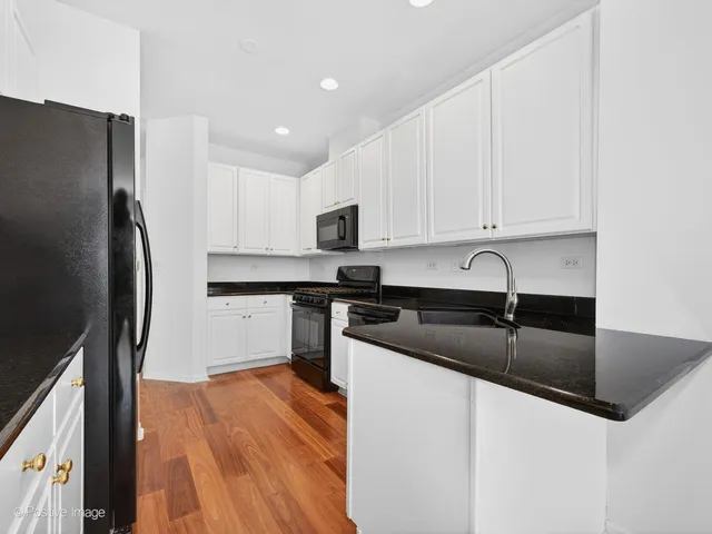 a kitchen with granite countertop a refrigerator sink and stove
