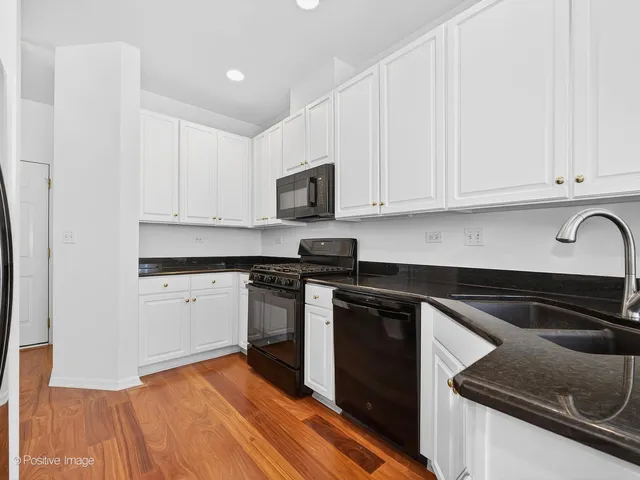 a kitchen with granite countertop cabinets stainless steel appliances and a sink