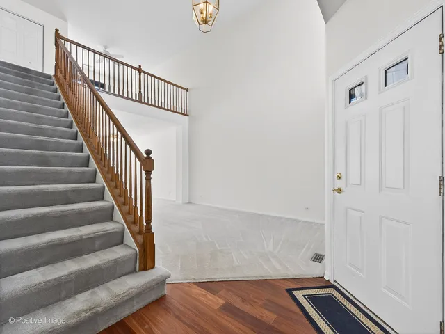 a view of staircase with wooden floor and white walls