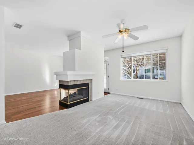 a view of an empty room with a fireplace and a window