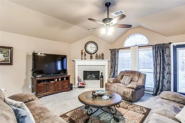 a living room with furniture a fireplace and a flat screen tv