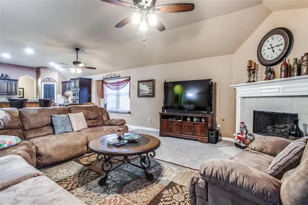 a living room with furniture a flat screen tv and a clock