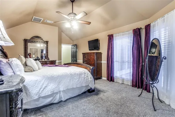 a spacious bedroom with bed and a chandelier