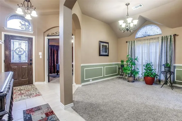 a view of a livingroom with a chandelier furniture and windows