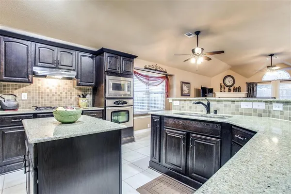 a kitchen with a sink stainless steel appliances and cabinets