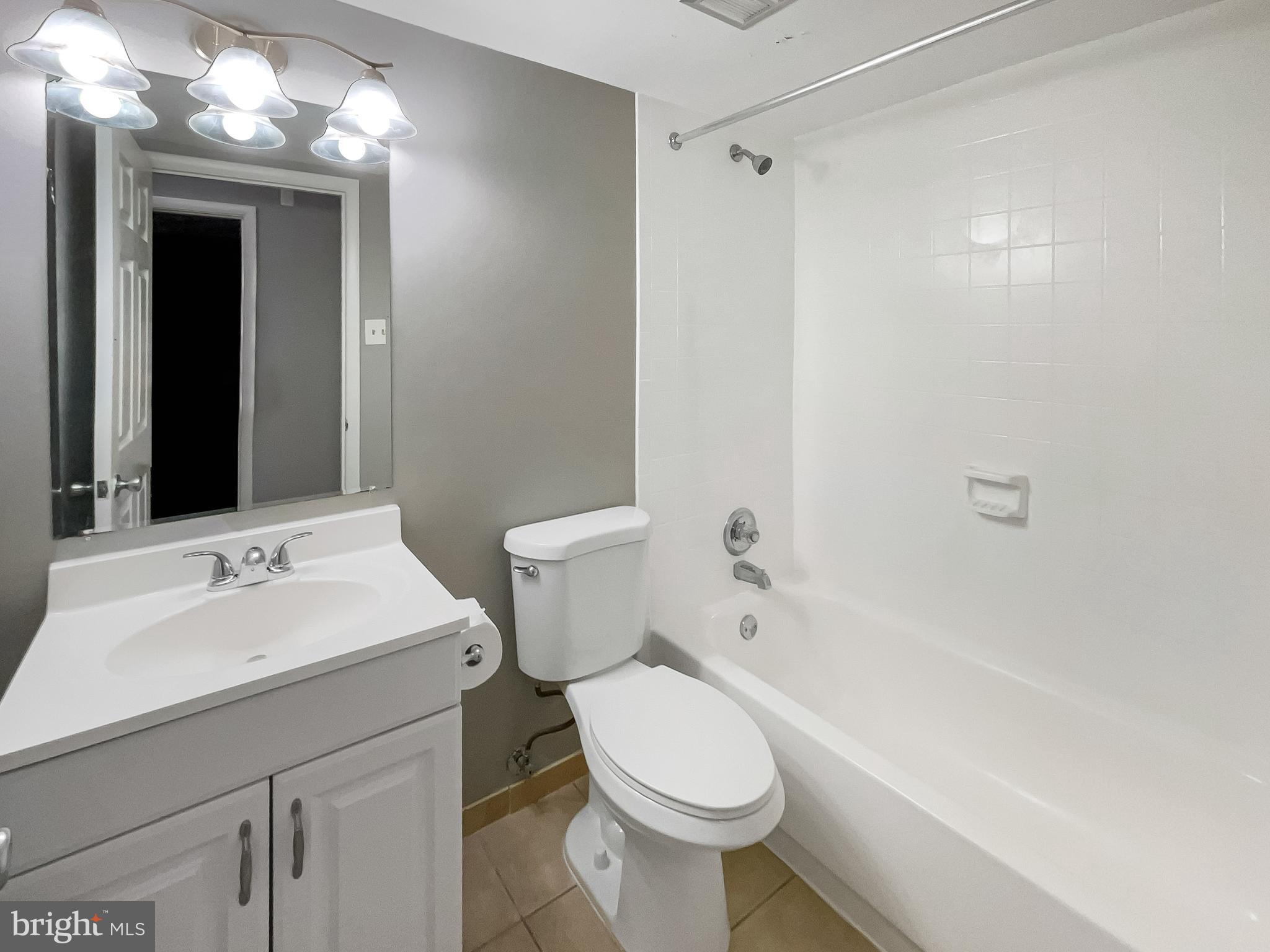 11204 Chestnut Grove Square, Unit 206 Reston, VA 20190 - Photo 13 of 18 a bathroom with a sink a toilet and shower