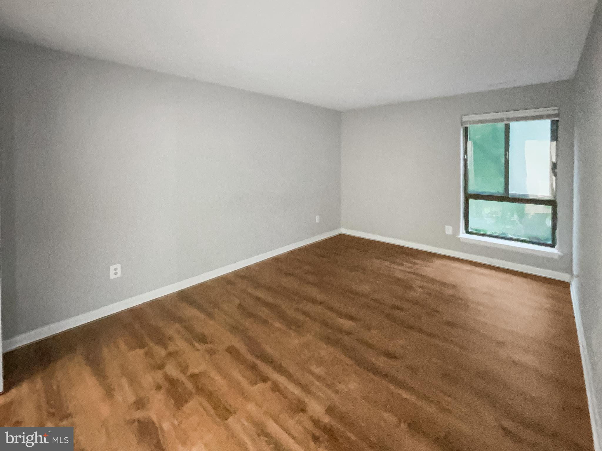 11204 Chestnut Grove Square, Unit 206 Reston, VA 20190 - Photo 14 of 18 wooden floor in an empty room with a window