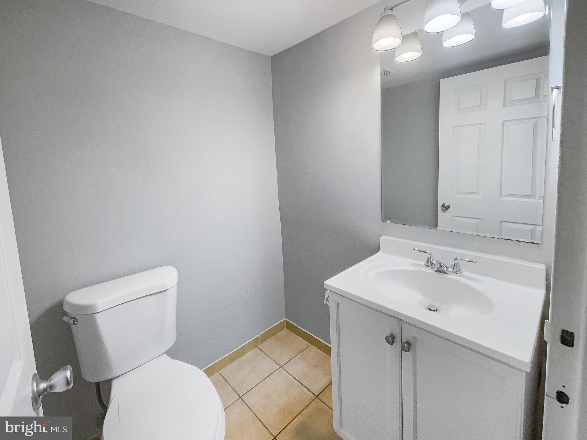 11204 Chestnut Grove Square, Unit 206 Reston, VA 20190 - Photo 15 of 18 a bathroom with a sink mirror vanity and toilet