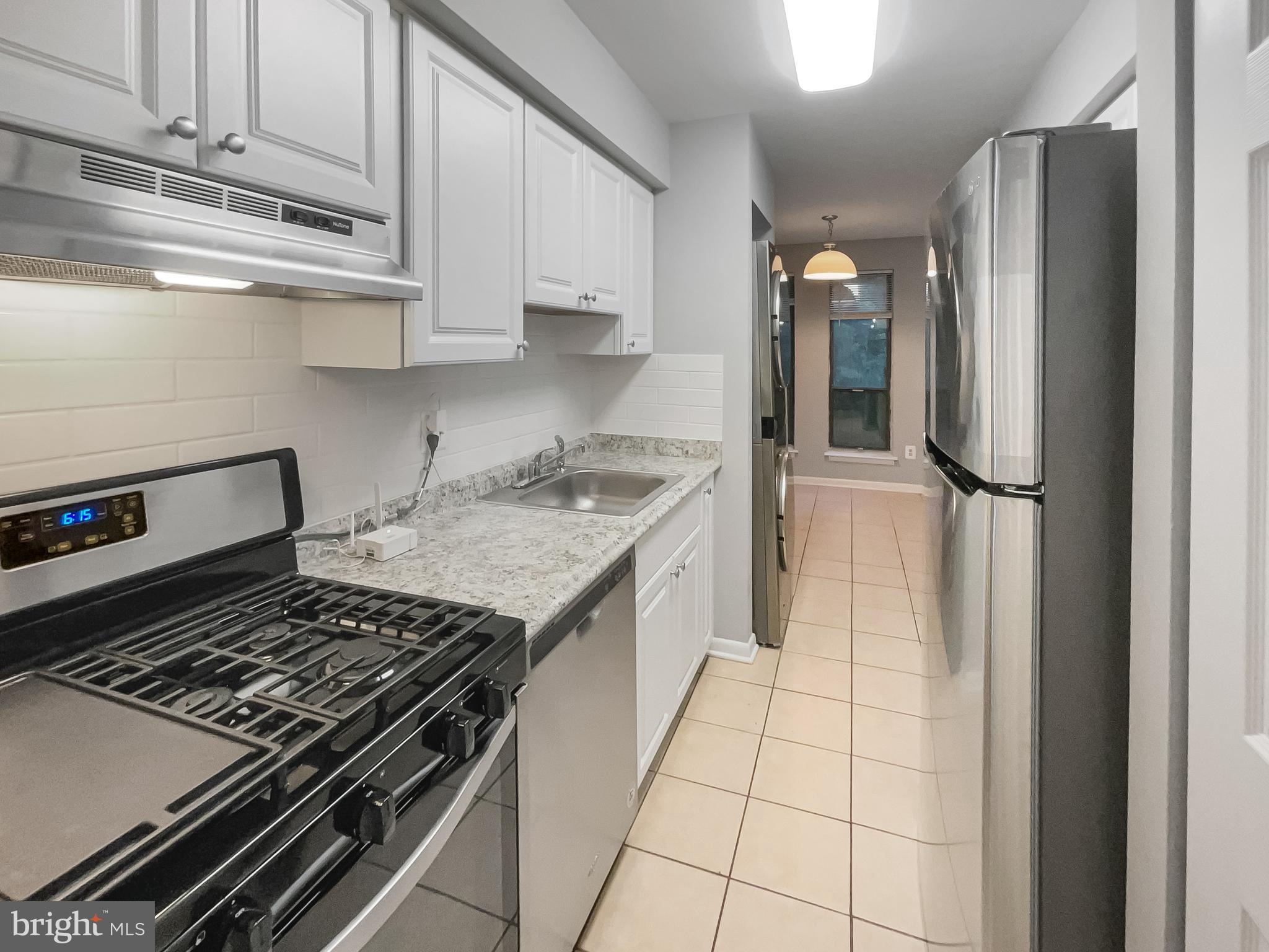 11204 Chestnut Grove Square, Unit 206 Reston, VA 20190 - Photo 2 of 18 a kitchen with a stove a refrigerator and cabinets