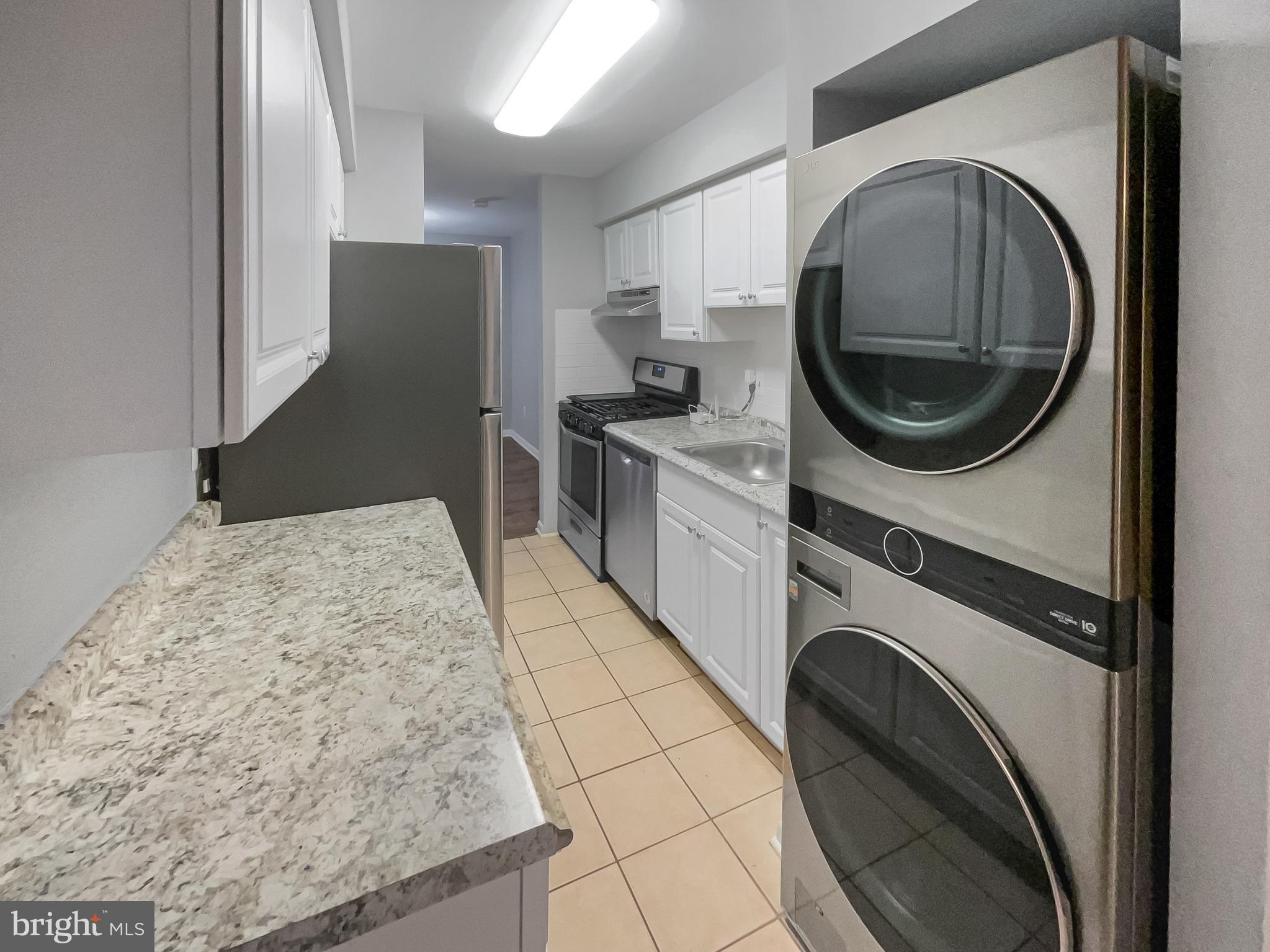 11204 Chestnut Grove Square, Unit 206 Reston, VA 20190 - Photo 9 of 18 a kitchen with a washer and dryer