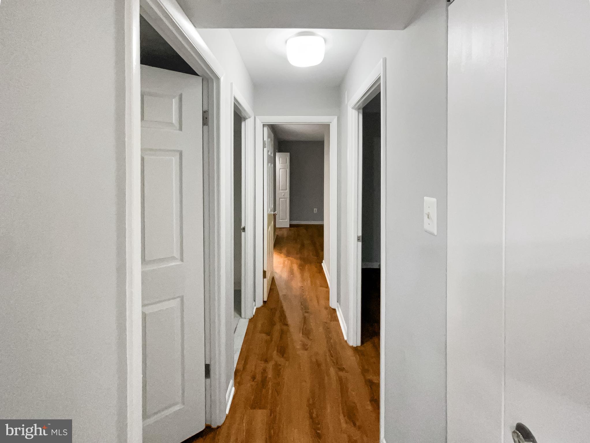 11204 Chestnut Grove Square, Unit 206 Reston, VA 20190 - Photo 10 of 18 a view of a hallway with wooden floor and a bathroom