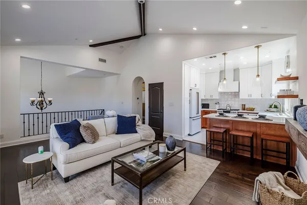 a living room with stainless steel appliances kitchen island granite countertop furniture and a view of kitchen