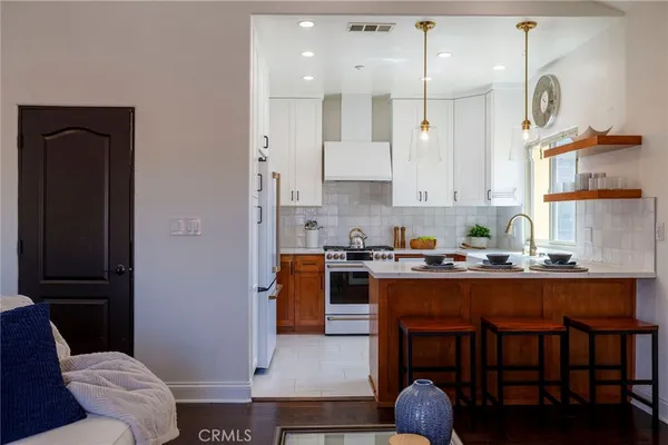 a kitchen with granite countertop a sink cabinets stainless steel appliances and windows