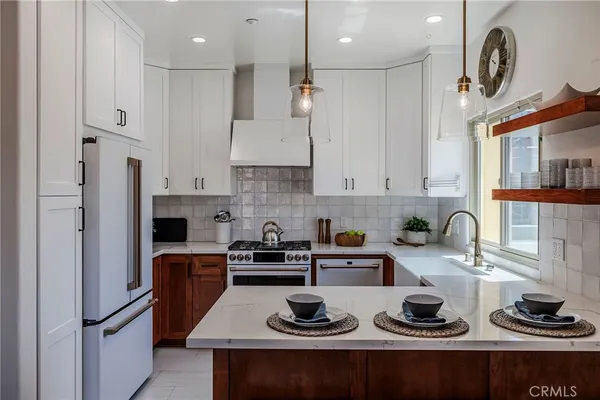a kitchen with refrigerator a stove a sink and cabinets
