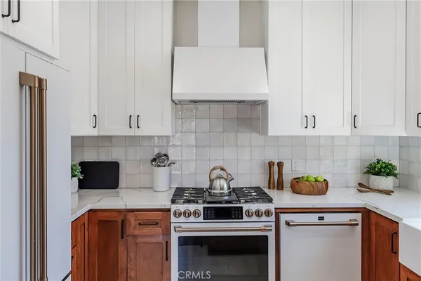 a kitchen with a stove and white cabinets