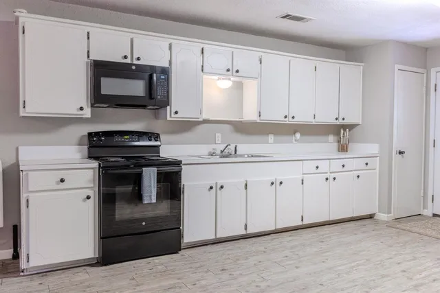 a kitchen with white cabinets stainless steel appliances and sink