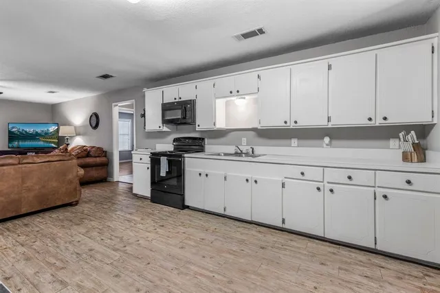 a kitchen with cabinets stainless steel appliances and a window