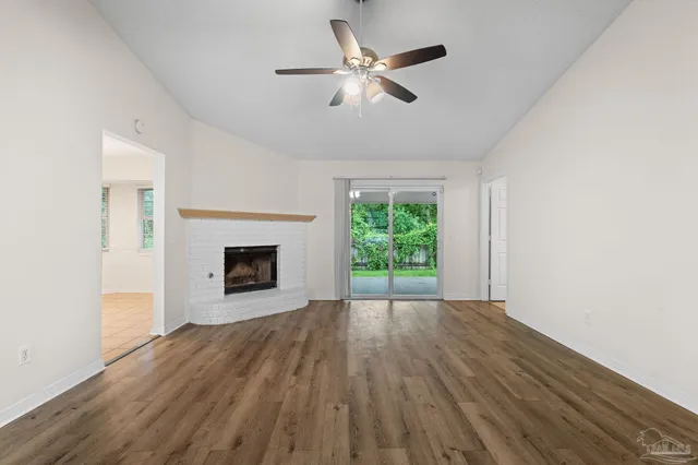 a view of an empty room with a fireplace and a window