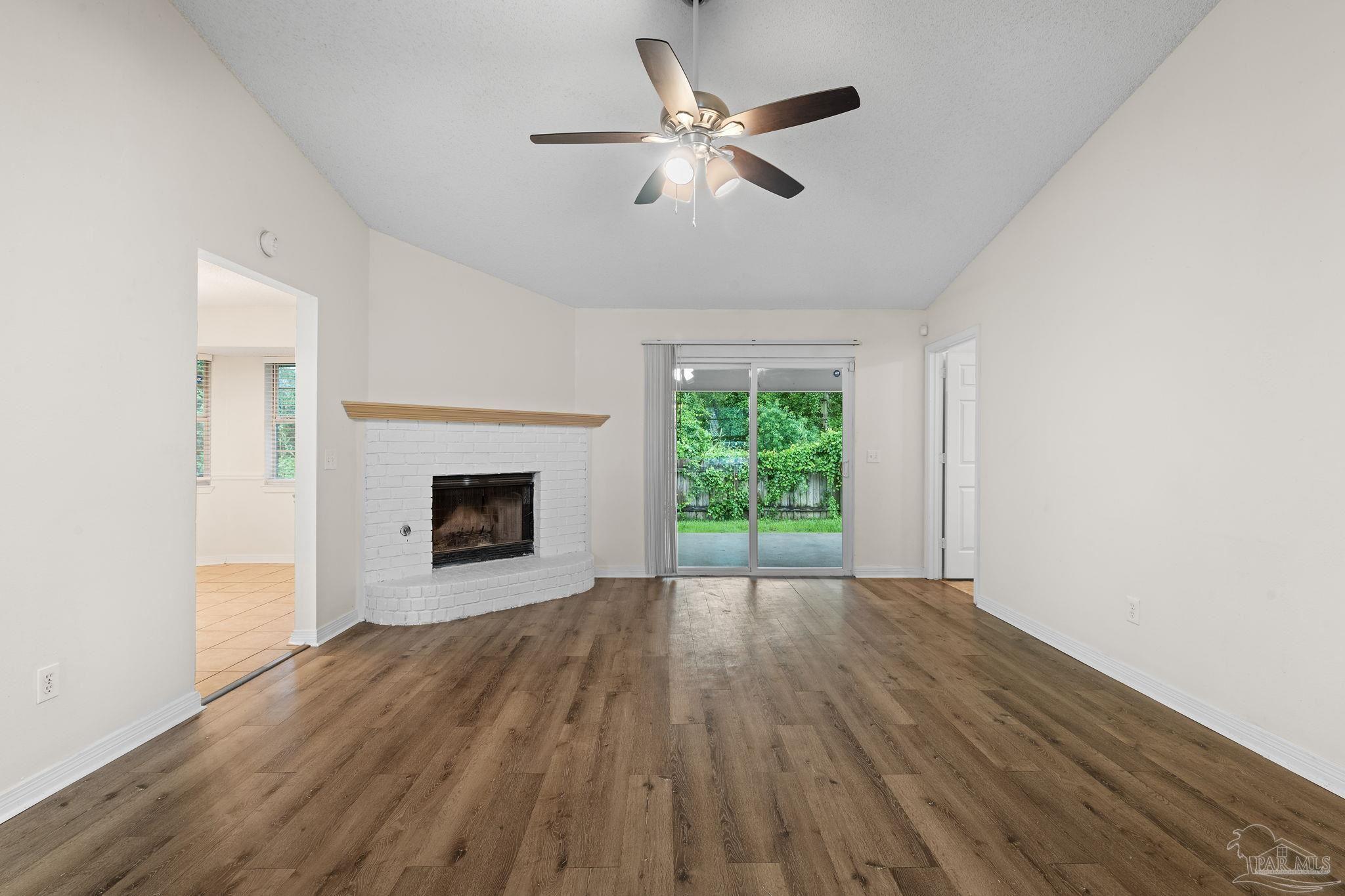 1203 Brook Bend Road Pensacola, FL 32506 - Photo 3 of 17 a view of an empty room with a fireplace and a window