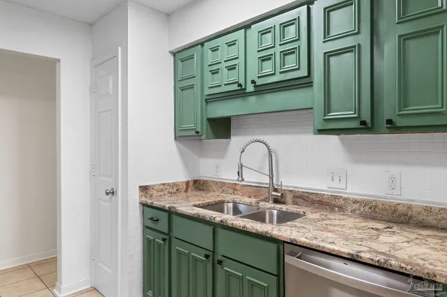 a kitchen with granite countertop a sink and cabinets